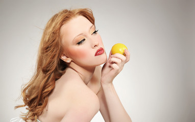 Obraz na płótnie Canvas Young attractive woman holding a lemon