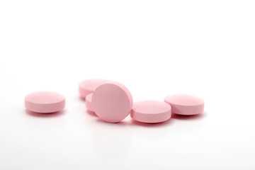 Obraz na płótnie Canvas Różowe tabletki na białym tle