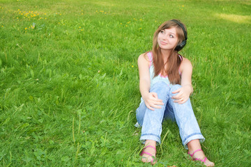 Portrait of the beautiful girl listening to music in ear-phones