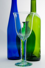 Weinglas mit leeren Flaschen