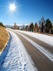 Shot of the sun shining on the road in a winter.