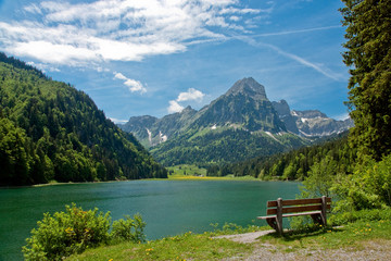 Park bench on shore of mountain lake - 15604268