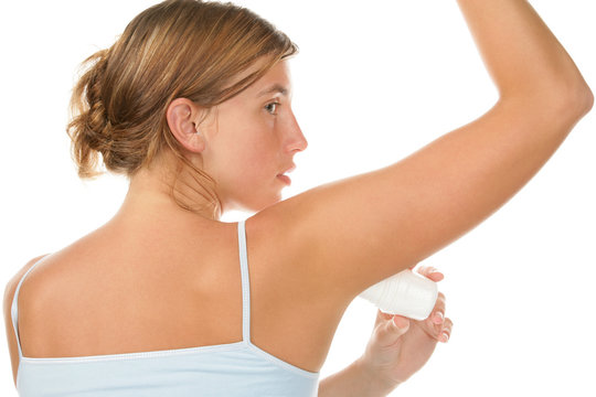 Portrait of young woman using deodorant