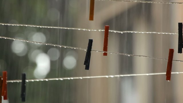 Rain falling over clothesline with clothespins