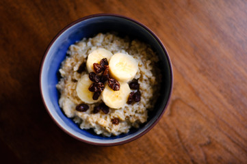 bowl of oatmeal with bananas and raisins
