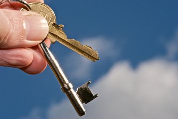 Holding new property keys against a bright blue sky.