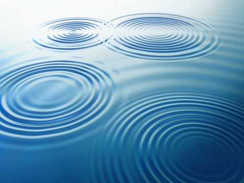 Fototapeta Wassertropfen fallen auf eine Wasserflaeche