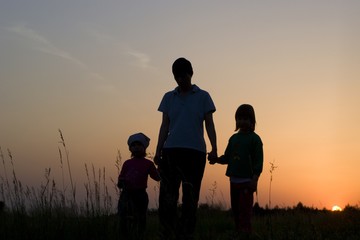 Fototapeta na wymiar mater and children - silhouette by sunset