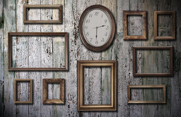 empty frames and watch on wooden wall