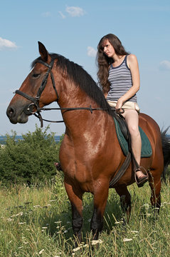 Girl sits on horseback