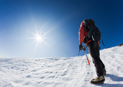 Climber reaching the summit of a mountain peak