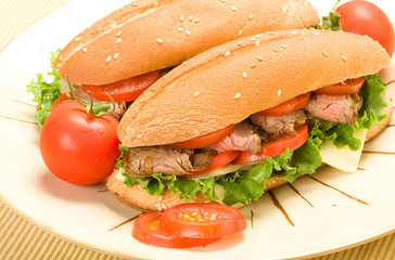 Steak Sandwiches on plate accompanied by tomato