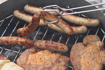Schweinsbratwürstchen und Halsgrat auf dem Grill