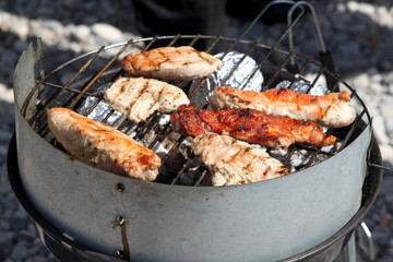 Grill mit Grillfleisch und Folienkartoffeln