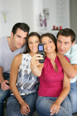 Hommes et femmes se photographiant avec un téléphone portable