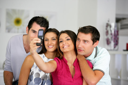 hommes et femmes se photographiant avec un téléphone portable