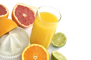 Juicer with slices of citruses and glass of fresh orange juice i