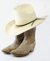 Worn cowboy boots with straw hat