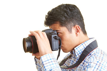 Mann schaut durch eine digitale Spiegelreflexkamera