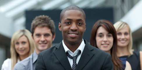 Obraz premium Afro-American businessman smiling at the camera with his team