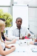 Afro-American businessman drinking champagne in office