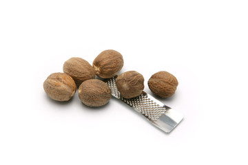 Noix de muscade et petite râpe sur fond blanc