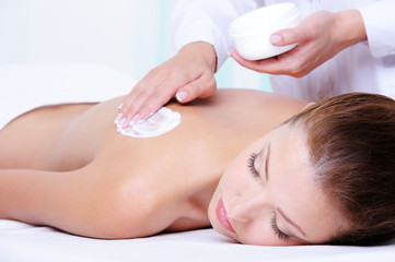 Applying  moisturizing cream on the female back