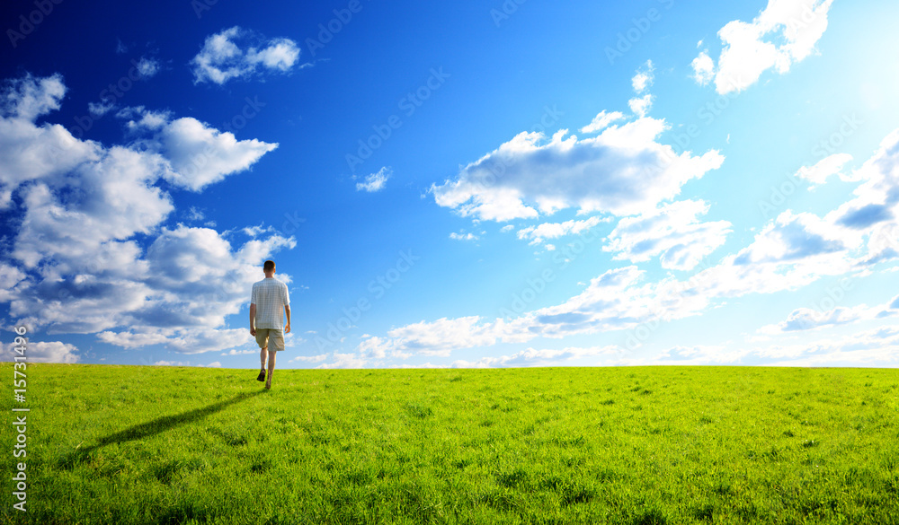 Wall mural one man and field of spring grass and sunset