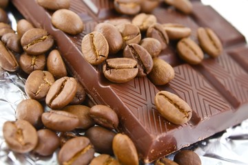 Aromatic milk chocolate and coffee grains on foil