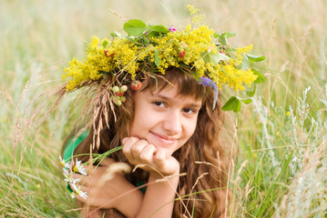 A young girl lies on a meadow
