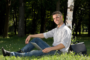 Obraz premium happy businessman working with laptop in the park