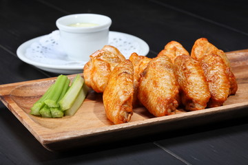 Grilled chicken wings served on wooden board