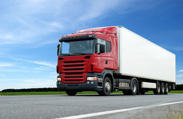 red lorry with white trailer over blue sky