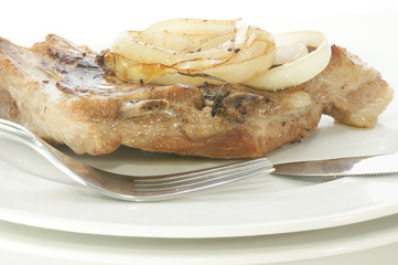 grilled pork rips with onion rings on a plate