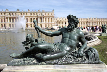 Statue d'un homme sur fond de château de Versailles
