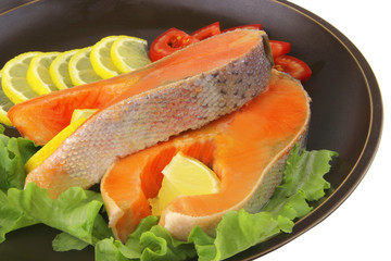 two salmon steak on dark dish