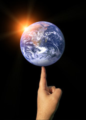 Concept Image of The Earth Balancing on a Finger