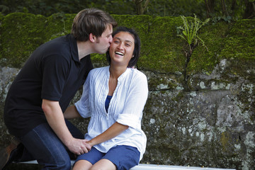 Man kisses his wife on the bench