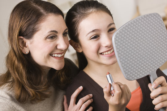 Smiling Mom And Daughter With Lipstick, Looking At Mirror