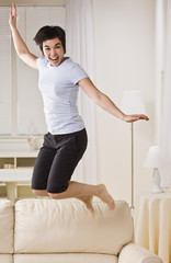 Fototapeta na wymiar Woman Jumping on Couch