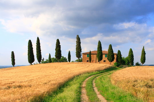 Wanderweg unter Wolkenhimmel, Haus in der Toskana