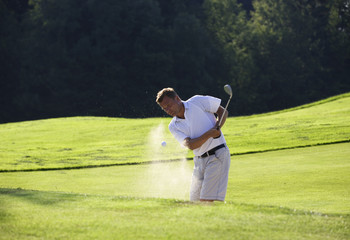 Golfspieler beim abschlag im Sandbunker,