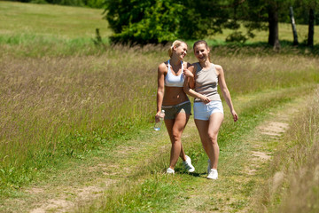 Fototapeta premium Female couple walking in meadow