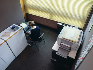 Office with secretary Top view of a small office with secretary writing, and photocopier. Photo from 1995