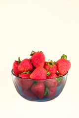 Strawberries in a bowl isolated on a white background.