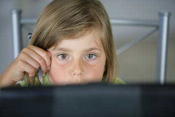 Portrait d'une petite fille devant un ordinateur portable