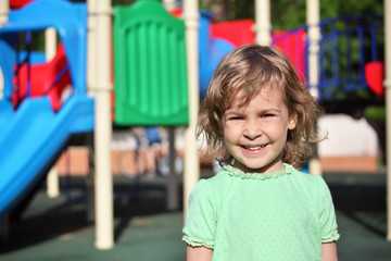 Fototapeta na wymiar Little smiling girl on playground