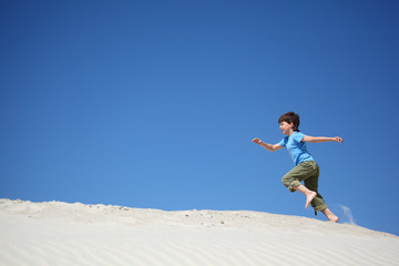 boy runs on sand
