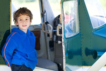 boy standing beside a plane
