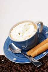 blaue tasse kaffee mit knusperröllchen und Sahne